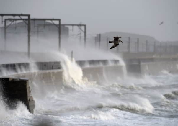 Waves crash over a wall near Saltcoats station yesterday as gales battered Scotland. Picture: Getty