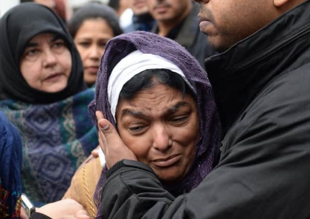 Fatima Khan, the mother of Dr Abbas Khan, is comforted by her son Afroze Khan. Picture: PA