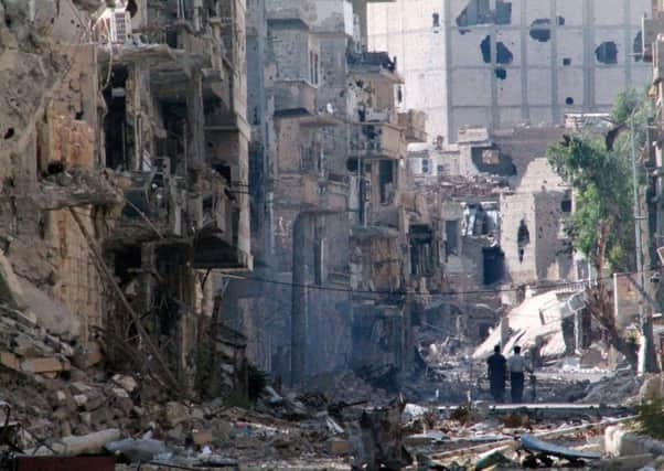 Syrians walk down a destroyed street in the centre of Deir Ezzor. Picture: Getty