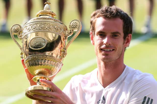 Andy Murray gets his hands on the Wimbledon trophy after a victory in his home grand slam. Picture: Getty