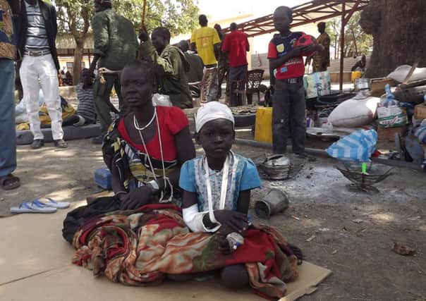 A wounded child sits with a relative after receiving treatment at Malakal Hospital. Picture: AFP
