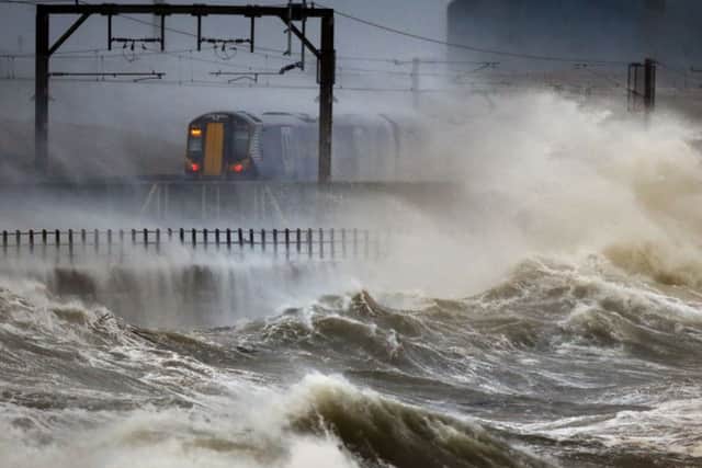 A ScotRail train passes through stormy Saltcoats. Picture: PA