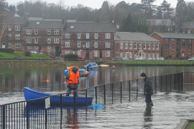 Two men try to retrieve their sunken dinghy at Dumbarton. Picture: Robert Perry