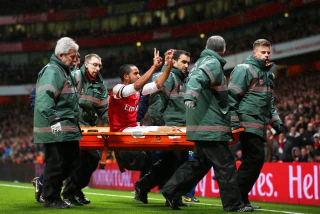 Theo Walcott gestures to the Spurs fans as he leaves the field injured with his side 2-0 ahead. Picture: Getty