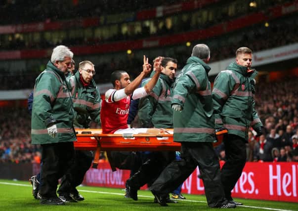 Theo Walcott gestures to the Spurs fans as he leaves the field injured with his side 2-0 ahead. Picture: Getty