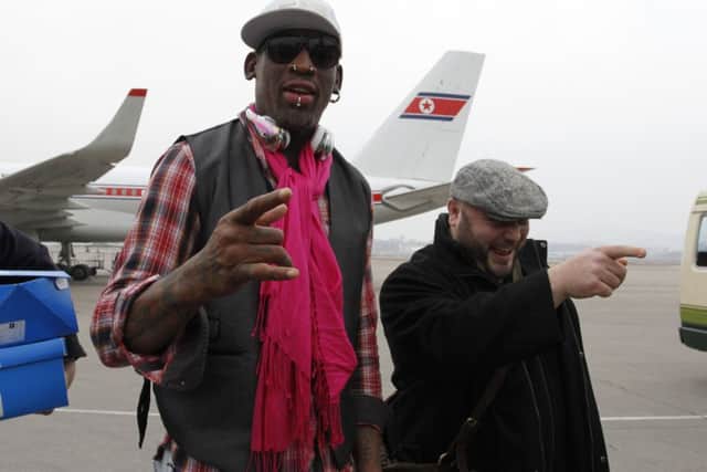 Dennis Rodman (L) arrives at the international airport in Pyongyang, North Korea. Picture: AP