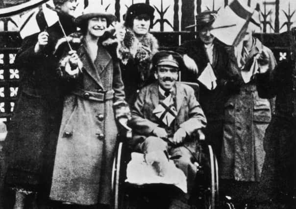 A group of women with a disabled ex-serviceman celebrating the end of World War I on Armistice Day, 11th November 1918. Picture: Topical Press Agency/Hulton Archive/Getty