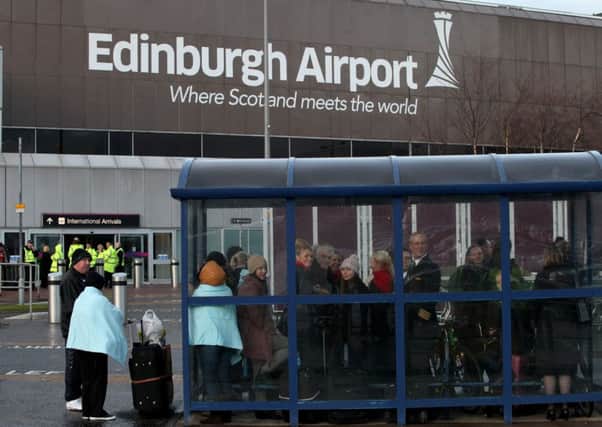 Passengers wait outside the airport. Picture: Hemedia