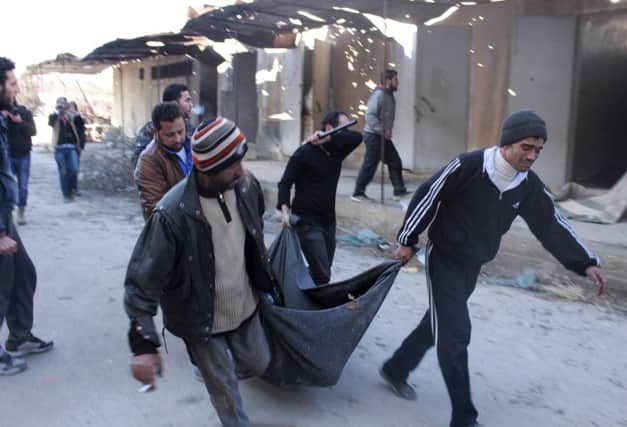 Men carry a body after it was discovered at Isis headquarters in Aleppo. Picture: Reuters