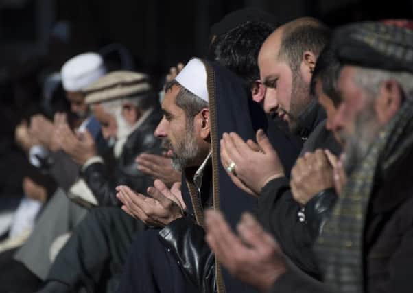 Afghan men pray outside a Kabul mosque. Picture: Getty