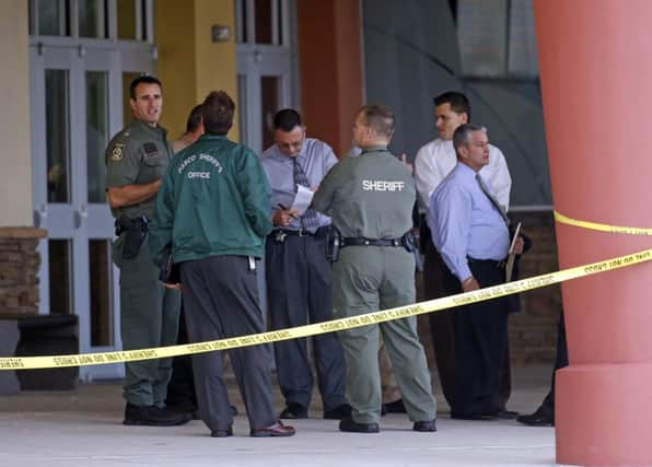 Sheriff officers speak with investigators at the cinema. Picture: Reuters