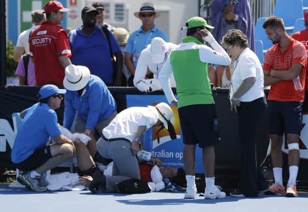 Officials surround Frank Dancevic after his collapse. Picture: AP