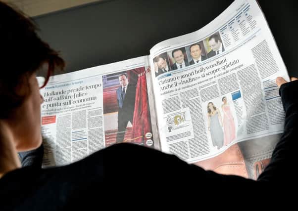 A woman reads a page of an Italian newspaper the day after a press conference held by French president Francois Hollande. Picture: Getty