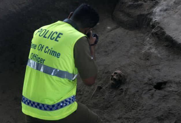 An officer photographs a skull in the mass grave in Mannar. Picture: Reuters