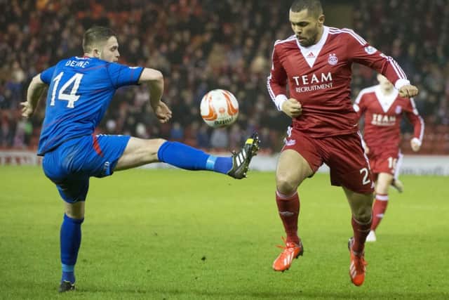 Aberdeen's Josh Magennis (right) skips past Danny Devine. Picture: SNS