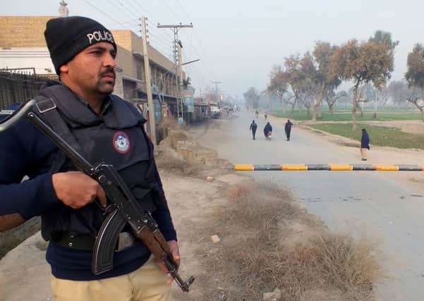 A policeman stands guard near the site of a bomb attack on a security convoy in Bannu. Picture: AFP/Getty