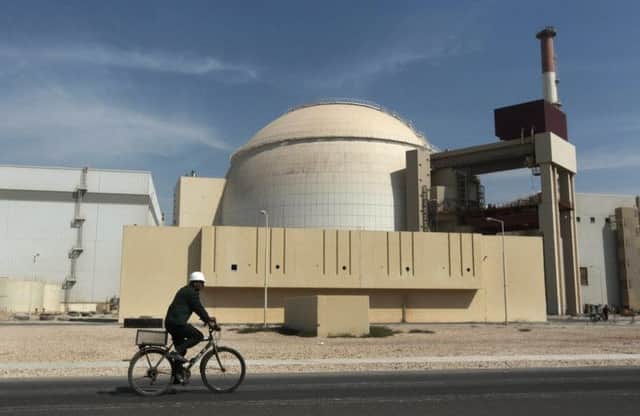 A cyclist passes one of Irans nuclear plants. Picture: AP