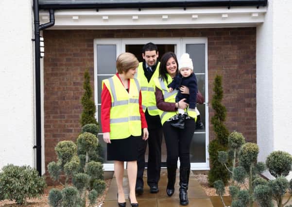 Deputy First Minister Nicola Sturgeon (left) with new homeowners Phil and Joanne MacFarlane. Picture: PA