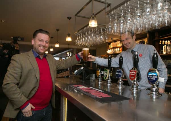 A customer buys the first pint from shift manager Derek at the new JD Wetherspoon pub called Hope And Champion on the M40. Picture: PA