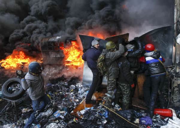 A pro-integration protester throws stones towards riot police in Kiev. Picture: Reuters