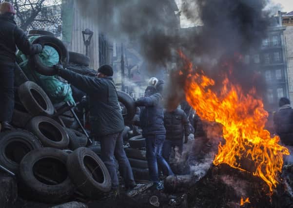 Anti-government protestors add tyres to a Kiev barricade. Picture: Getty