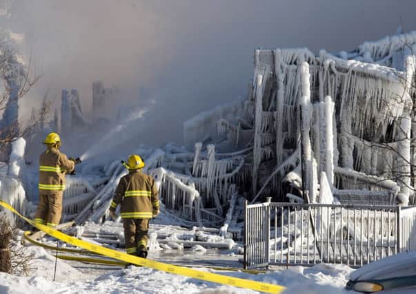 Firefighters douse the rubble at the site of the L'Isle-Verte care home. Picture: AP
