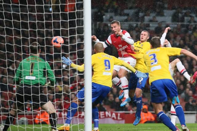 Arsenal's Lukas Poldoski heads home his second goal. Picture: AP