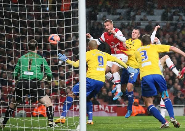 Arsenal's Lukas Poldoski heads home his second goal. Picture: AP
