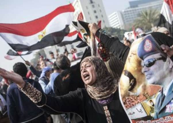 Pro-regime demonstrators carry images of the chief of the army, General Abdel Fattah al-Sisi. Picture: Getty