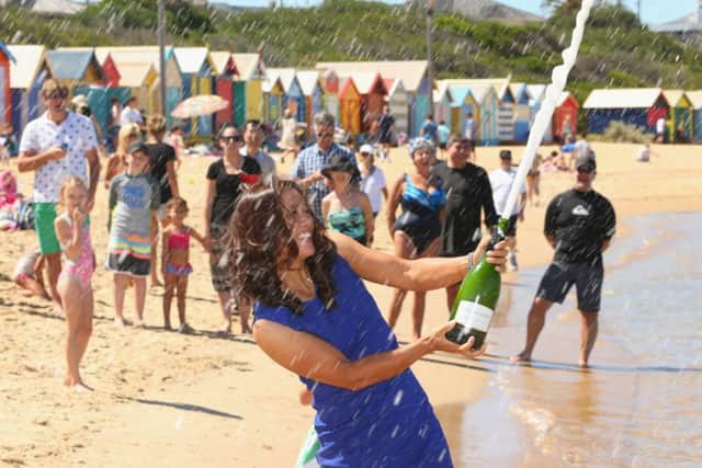 Australian Open champion Li Na sprays champagne on Brighton Beach. Picture: Getty