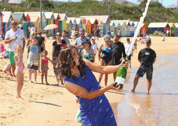 Australian Open champion Li Na sprays champagne on Brighton Beach. Picture: Getty
