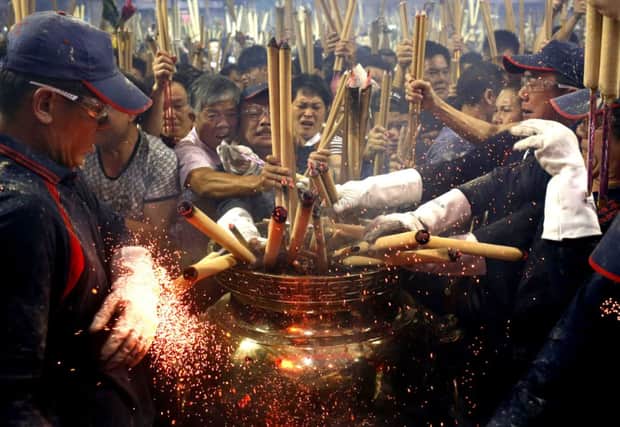 People rush to plant the first joss stick of the Chinese New Year at a temple in Singapore. Picture: Reuters