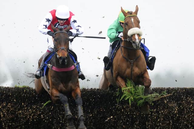 Aidan Coleman and Bennys Mist, left, clear the last to win The Dick Hunter Handicap Steeple Chase. Picture: Getty