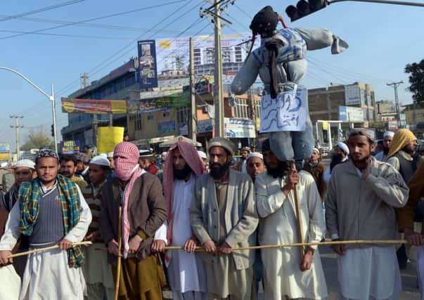 Pakistani fundamentalists hold an effigy of the author of an alleged anti-Islamic book as they call for him to be prosecuted for blasphemy. Picture: Getty