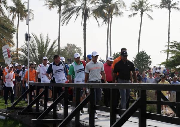 Tiger Woods leads a group including Rory McIlroy over a bridge during the second round in Dubai yesterday. Picture: Getty Images