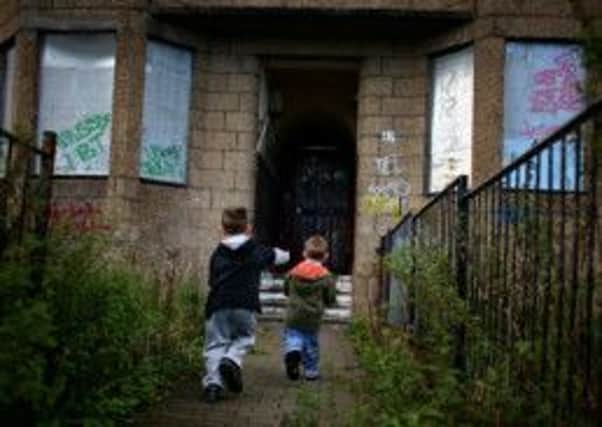 Two boys run towards boarded-up houses in Glasgows Govan. Photograph: Jeff J Mitchell/Getty