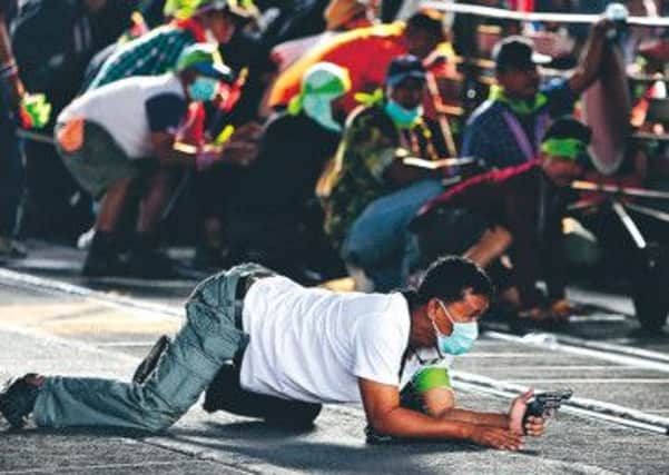 An anti-government protester crawls along the ground during a gunfight between opposing sides of the bitter political divide near Laksi district office in Bangkok. Photograph: Nir Ellias/Reuters