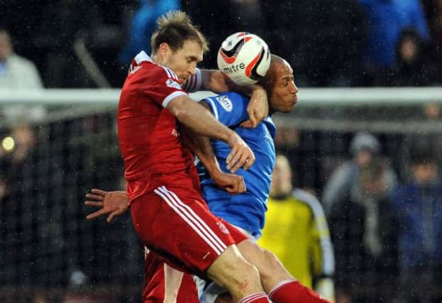 Aberdeen's Russell Anderson is upended by Christopher Iwelumo. Picture: Ian Rutherford