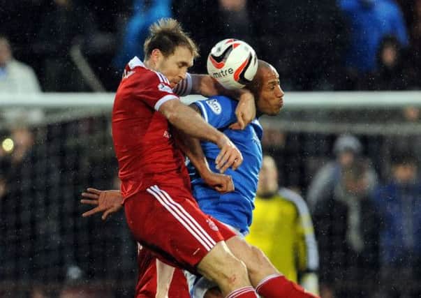 Aberdeen's Russell Anderson is upended by Christopher Iwelumo. Picture: Ian Rutherford