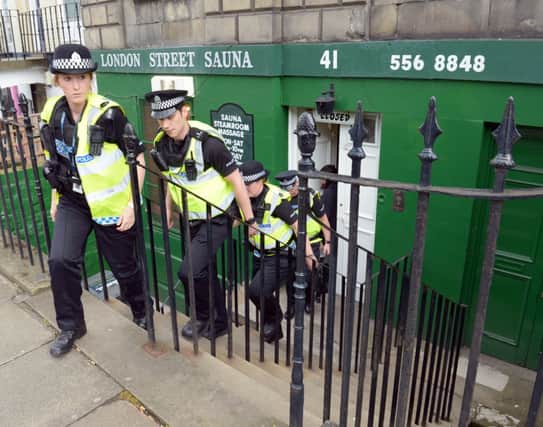 Police Scotland officers leave London Street sauna. Picture: Phil Wilkinson