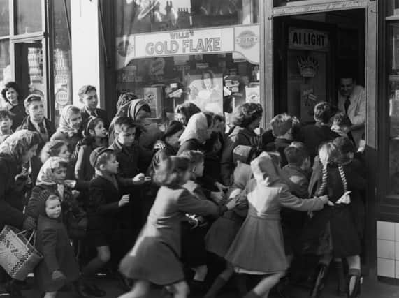 A crowd of children rush to get into a sweet shop as it opens its doors on the day rationing of sweets ended in 1953. Picture: Getty