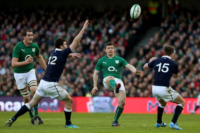 Brian O'Driscoll kicks over Scotland's Duncan Taylor and Stuart Hogg. Picture: PA