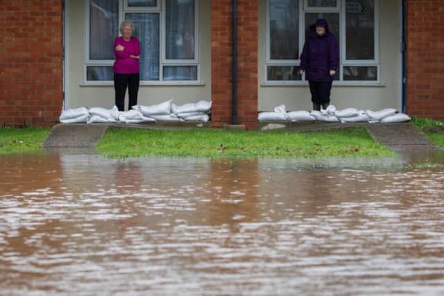 Residents Christine Brown and Madeleine Rose look out at rising flood water in the village of Ruishton, nr. Taunton, Somerset. Picture: SWNS
