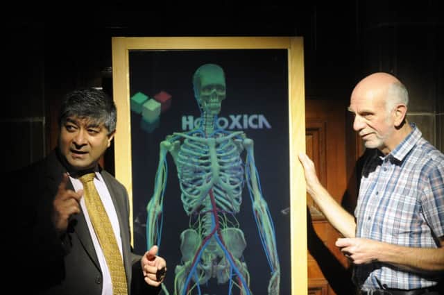 Holoxica founder Javid Khan, left, demonstrates the 3D display technology. Picture: Greg Mcvean