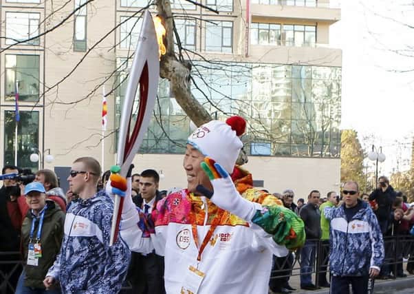 Ban KiMoon runs with the Winter Olympics torch as the relay arrives in Sochi. Picture: AFP/Getty