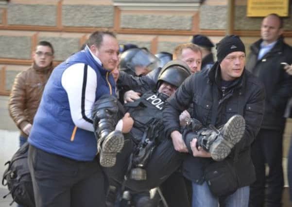 Citizens help an injured policeman during clashes in Sarajevo. Picture: Reuters