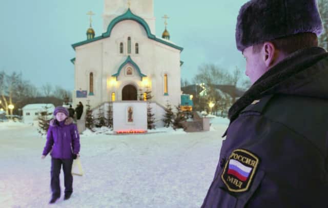 A police officer watches over the scene at the cathedral on Sakhalin Island. Picture: AFP/Getty Images