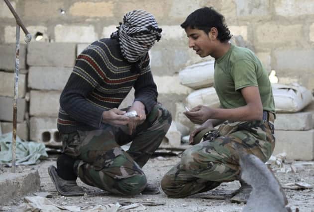 Free Syrian Army fighters light dynamite before throwing it towards Assad forces. Picture: Reuters