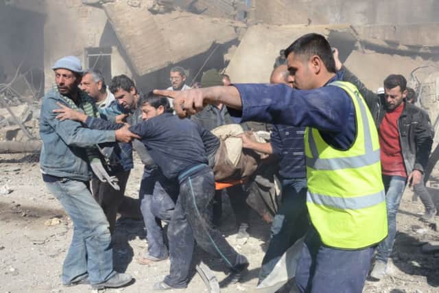 Men carry the wounded in Aleppo. Picture: Getty Images