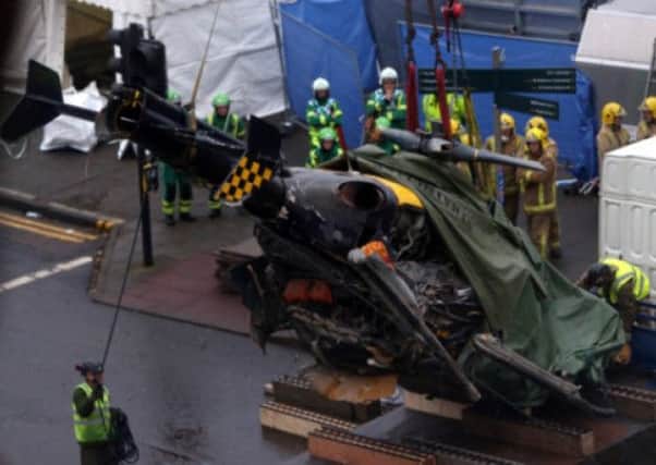 The wreckage of the police helicopter is lifted away from the pub. Picture: Getty